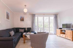 ein Wohnzimmer mit Sofa und Fernseher in der Unterkunft Haus WINDFLÜCHTER Whg. LF 6.1 in Wustrow