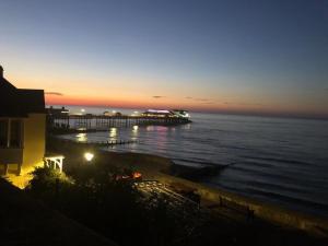 a view of a pier at sunset next to the ocean at CROMER FLAT ABDUL in Cromer