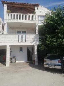 una casa blanca con un coche aparcado delante de ella en Guesthouse Alliya, en Dubrovnik