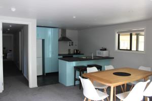 a kitchen and dining room with a wooden table and chairs at Scott Street Apartments in Lake Tekapo