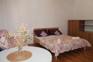 a bedroom with a bed and a table with a vase at Entire home with a swimming pool for 12 in Marusici in Marusici 