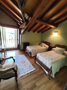 een grote kamer met 2 bedden en een stoel bij Posada La Casa de Lastras in Ogarrio