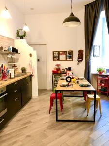 ナポリにあるM99 Design Roomsのキッチン(テーブル、赤い椅子付)