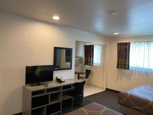 a room with a desk with a television and a bed at Super 8 by Wyndham Monterey in Monterey