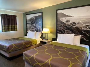 a hotel room with two beds and a picture on the wall at Super 8 by Wyndham Monterey in Monterey