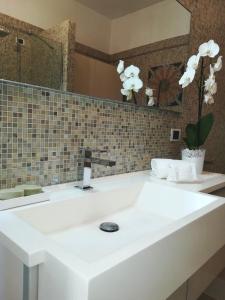 uma casa de banho com um lavatório branco e um espelho. em A CASA DI TATI em Civitanova Marche
