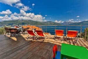 a deck with a table and chairs and a view of the water at Apartment 365 in Tivat