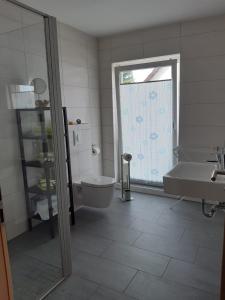 a bathroom with a tub and a toilet and a sink at DA Ferienwohnungen in Bargischow