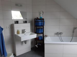 a bathroom with a sink and a bath tub at DA Ferienwohnungen in Bargischow