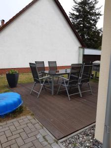 a patio with four chairs and a table and a frisbee at DA Ferienwohnungen in Bargischow