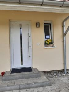 a white door on a house with a window at DA Ferienwohnungen in Bargischow