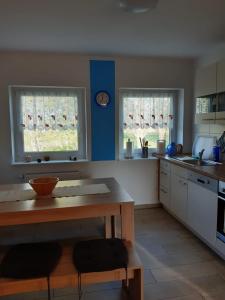 a kitchen with a table and two windows in it at DA Ferienwohnungen in Bargischow