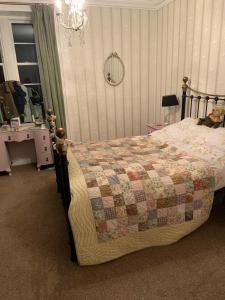 a bedroom with a bed with a quilt on it at The Law House in Coldingham