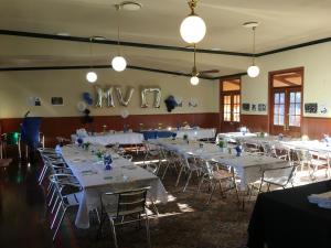 a banquet hall with white tables and chairs and lights at Bororen Hotel Motel in Bororen