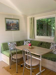 a living room with a table and a couch at Bungalow la Bouillerie animaux de la ferme in Gonneville-sur-Mer