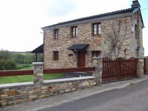 uma casa de tijolos com uma cerca e um portão em Casa Crisanta em Lomba