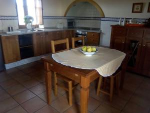 una cocina con una mesa con un bol de fruta. en Casa Crisanta, en Lomba