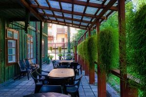 an outdoor patio with tables and chairs and plants at Pokoje Szczawnica Centrum - duży ogród in Szczawnica