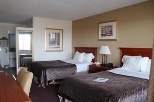 a hotel room with two beds and a desk at Dakota Inn in Huron