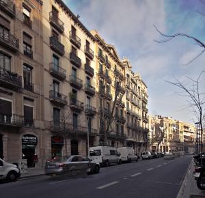 a city street with cars parked in front of buildings at Be Barcelona Eixample Urquinaona II in Barcelona