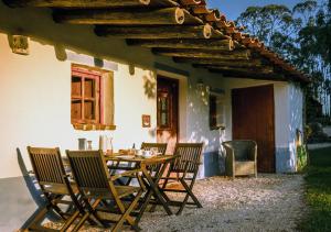 a wooden table and chairs on a patio at Cerro Da Fontinha in São Teotónio