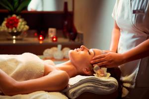 a woman getting a massage in a spa room at Yas Island Rotana Abu Dhabi in Abu Dhabi