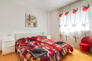 a bedroom with a bed and a red chair at Forum Beach in Sant Adria de Besos +45 photos