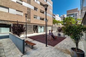 a woman on a ladder in a courtyard in a building at Forum Beach in Sant Adria de Besos