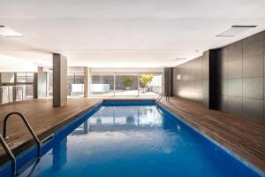 an indoor swimming pool with a wooden deck at Forum Beach in Barcelona