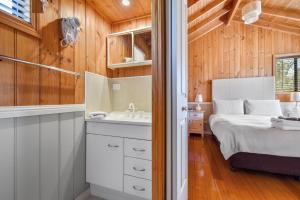 1 dormitorio con 1 cama y lavamanos en una habitación en Hazelcreek Cottages en Exeter