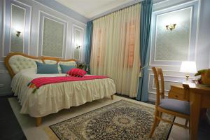 um quarto com uma cama com uma almofada vermelha em Sergei Palace Hotel em Jerusalém