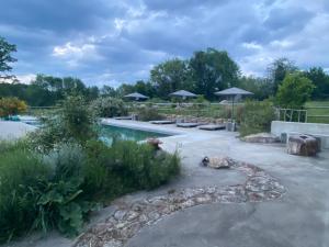 - une piscine dans une cour avec des parasols dans l'établissement Domaine de Combraille en Marche, à Saint-Médard