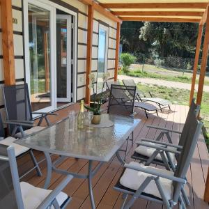 a patio with a table and chairs on a deck at Grand Veles camp in Pula