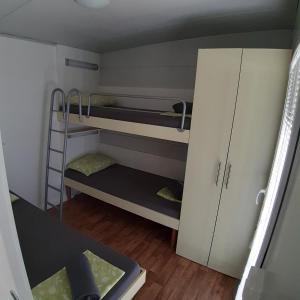 a small room with two bunk beds and a cabinet at Grand Veles camp in Pula