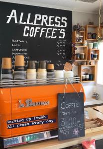 a coffee shop with a sign on the counter at Hahei Beach Resort in Hahei
