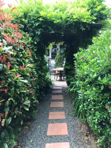 un sendero ajardinado con un arco con plantas y una mesa en Hillside Bed and Breakfast, en Huonville