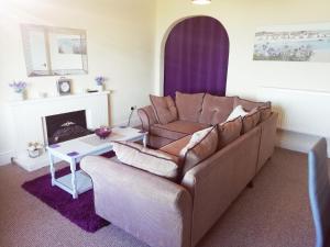 a living room with a couch and a fireplace at Llys Madoc, The Top Flat in Penmaen-mawr