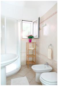 a white bathroom with a sink and a toilet at Appartamenti Corciulo in Salve