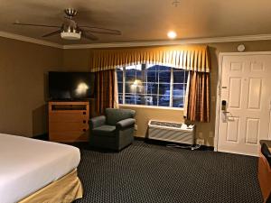 Habitación de hotel con cama, silla y ventana en Lake Point Lodge, en Clearlake Oaks