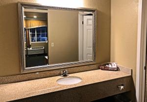 baño con lavabo y espejo grande en Lake Point Lodge, en Clearlake Oaks