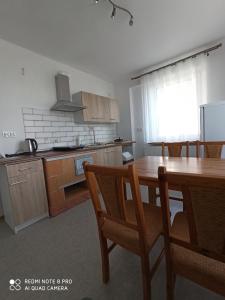 a kitchen with a wooden table and wooden cabinets at Villa Hillas in Reda