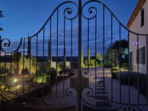 a gate with a view of a garden at night at Maison Sadina in Séguret