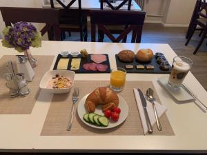 ein Frühstückstisch mit einem Teller Essen und Getränken in der Unterkunft Hotel Berg in Köln