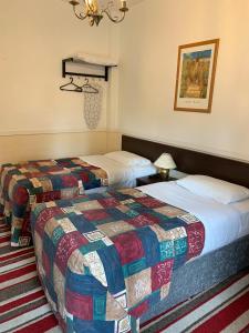 A bed or beds in a room at Strathpeffer Hotel 