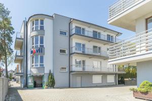 un edificio de apartamentos con balcones en una calle en Navii en Władysławowo