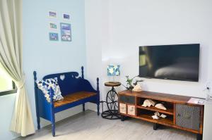 a living room with a blue chair and a tv at 1969 Meters Square Seed B&B in Jian