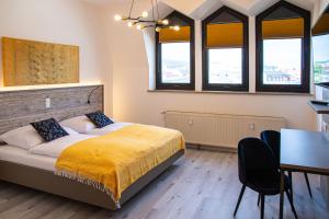- une chambre avec un lit, une table et des chaises dans l'établissement City Hotel Bamberg, à Bamberg