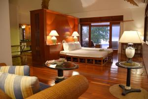 a bedroom with a bed and a living room at Badian Island Wellness Resort in Badian