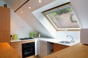 an attic kitchen with a sink and a window at Appartement du Commun au Château de Chanteloup in La Croix