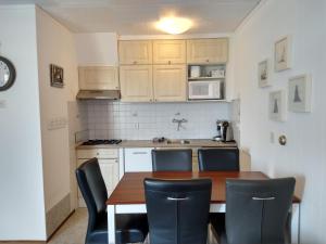 a kitchen with a wooden table and chairs at DUINZICHT 8 Bed by the Sea in Westkapelle